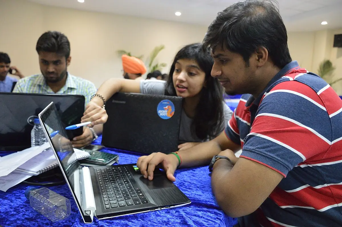 Participants discussing a laptop exercise at a Python workshop during WikiConference India 2016